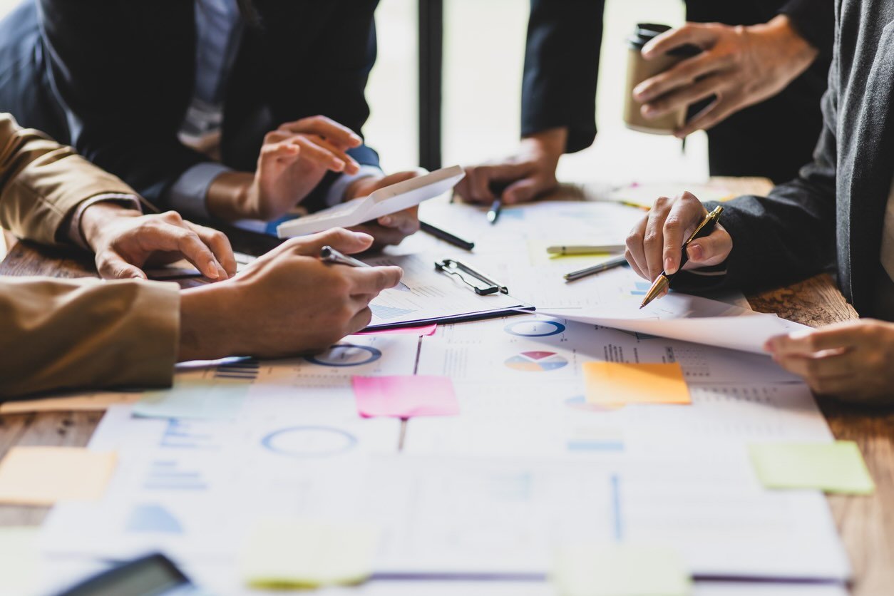People brainstorming around table with papers