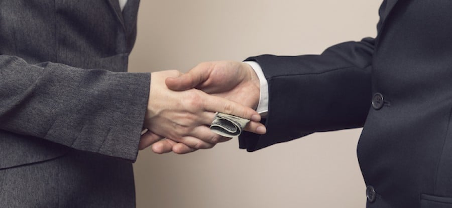 Bribe being expected with a handshake Bribe being expected with a handshake