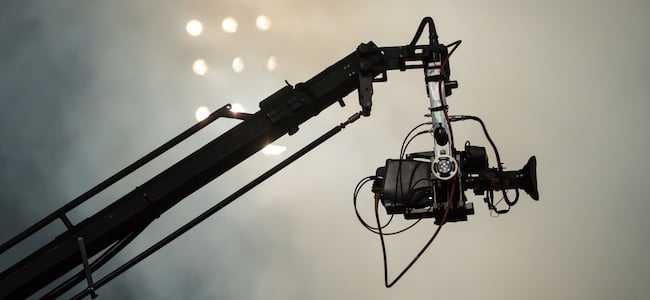 Camera suspended above sports field in front of floodlights