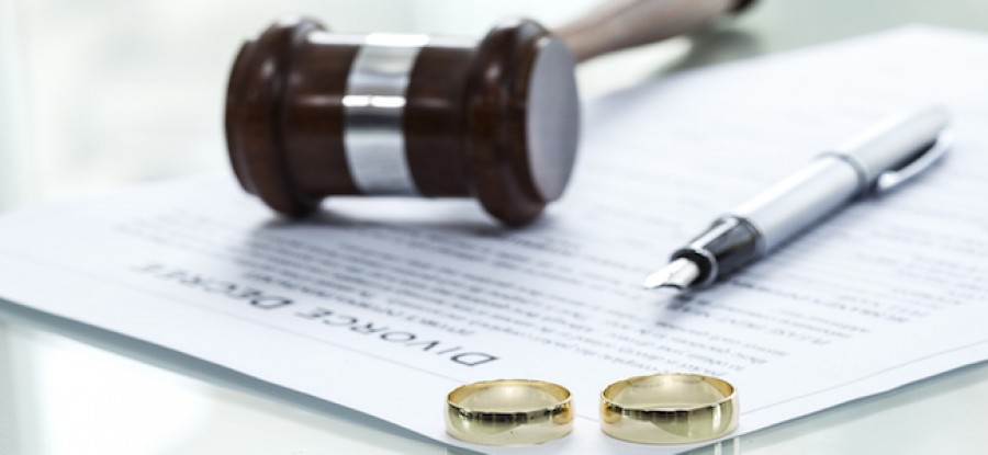 Divorce decree and wedding rings with pen and gavel