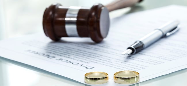 Divorce decree and wedding rings with pen and gavel Divorce decree and wedding rings with pen and gavel
