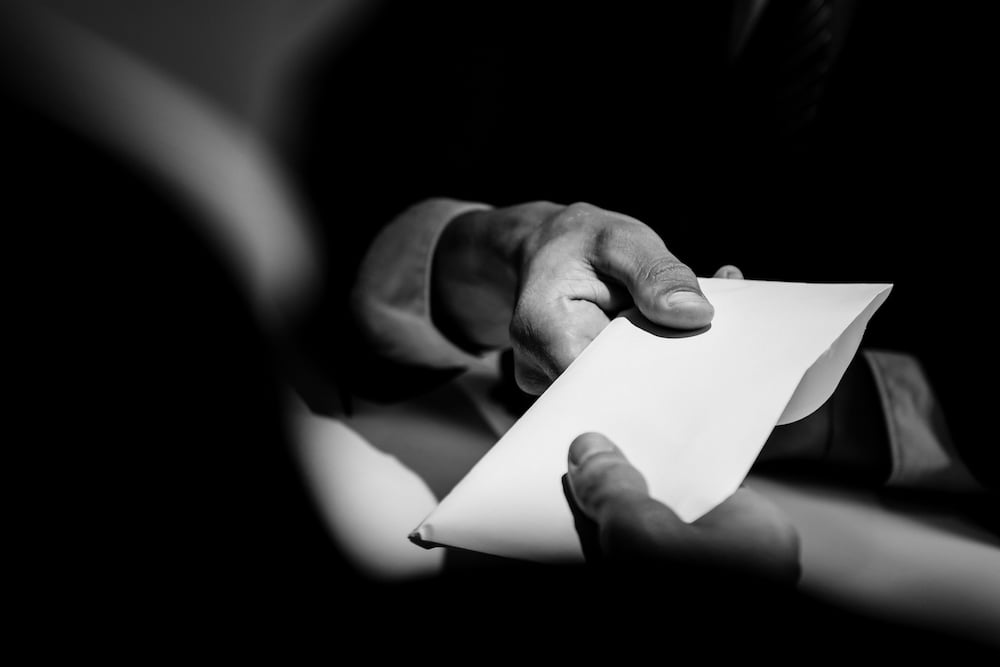 Envelope passing hands