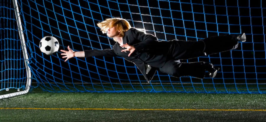 Female football player diving for ball in suit Female football player diving for ball in suit