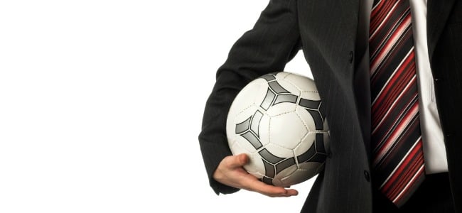 Football being carried by man in suit