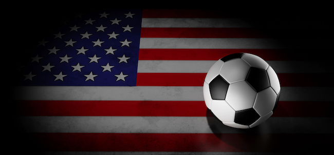 Football on American flag under spotlight