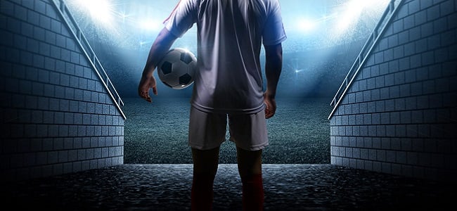 Football player carrying ball about to enter the stadium