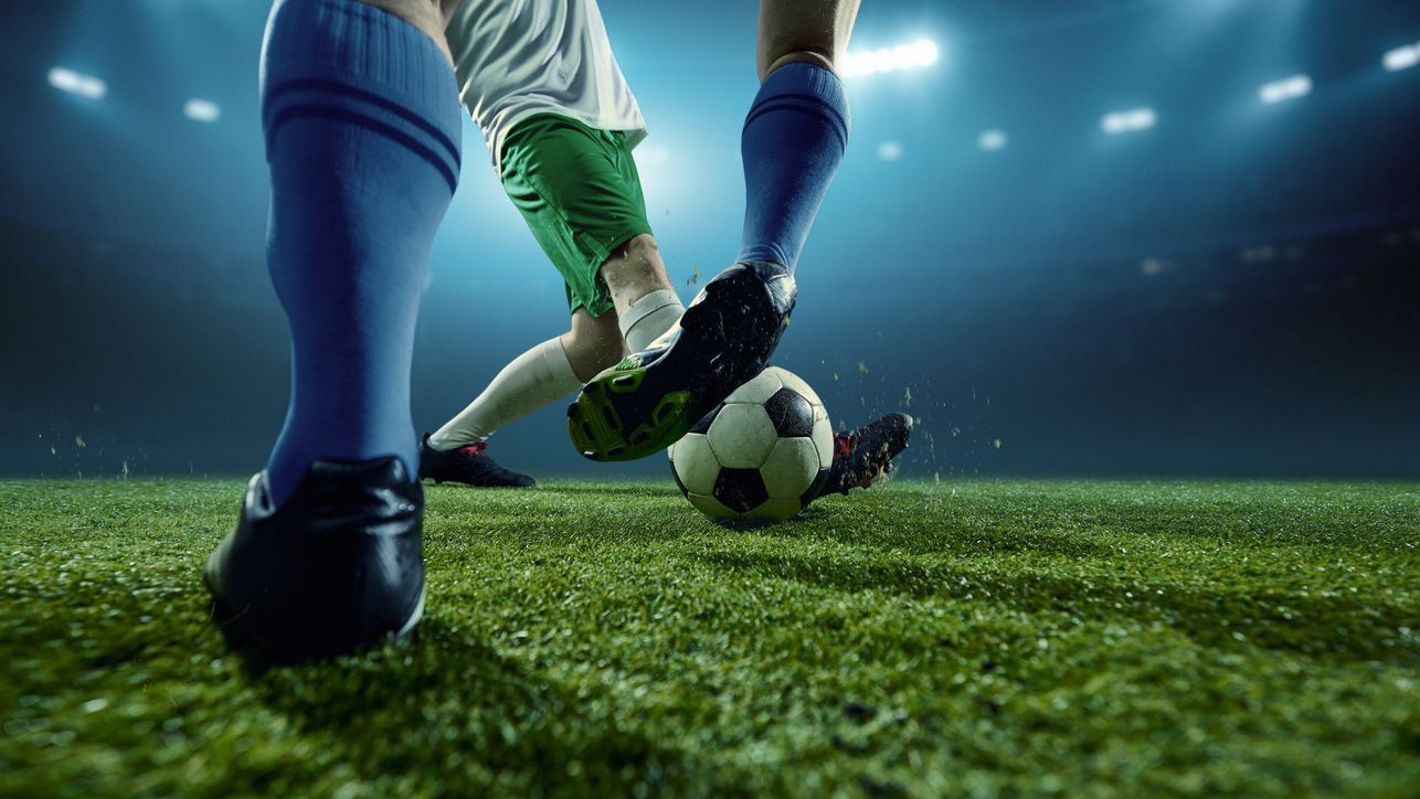 Title image of Footballers challenging for ball