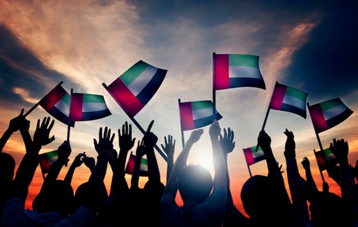 Group of people waving UAE flag