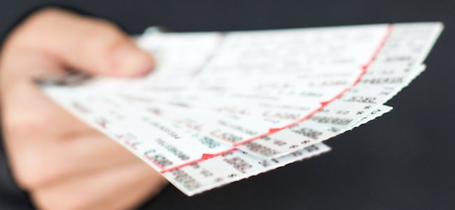 A person holding sports tickets in their hand