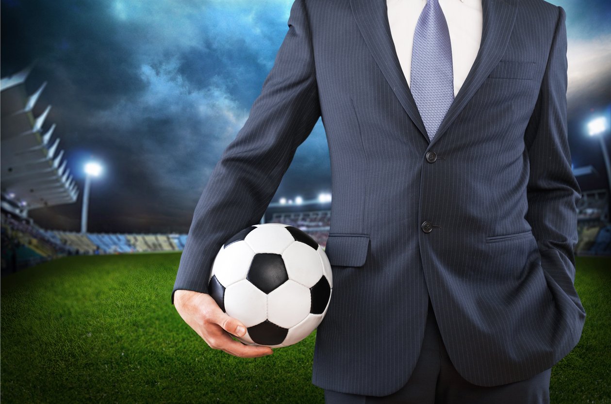 Man in suit with football in hand