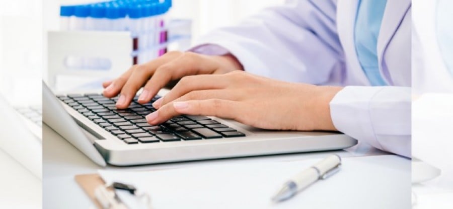 Scientist_on_Laptop_next_to_Vials Scientist_on_Laptop_next_to_Vials