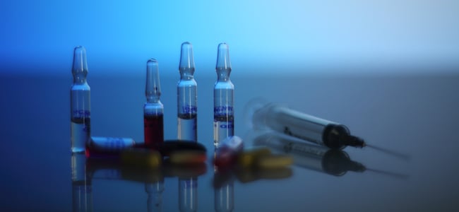 Syringe and capules on blue background