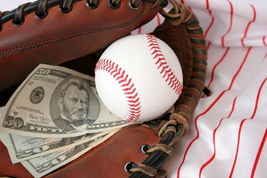 Baseball glove holding a ball and cash Baseball glove holding a ball and cash