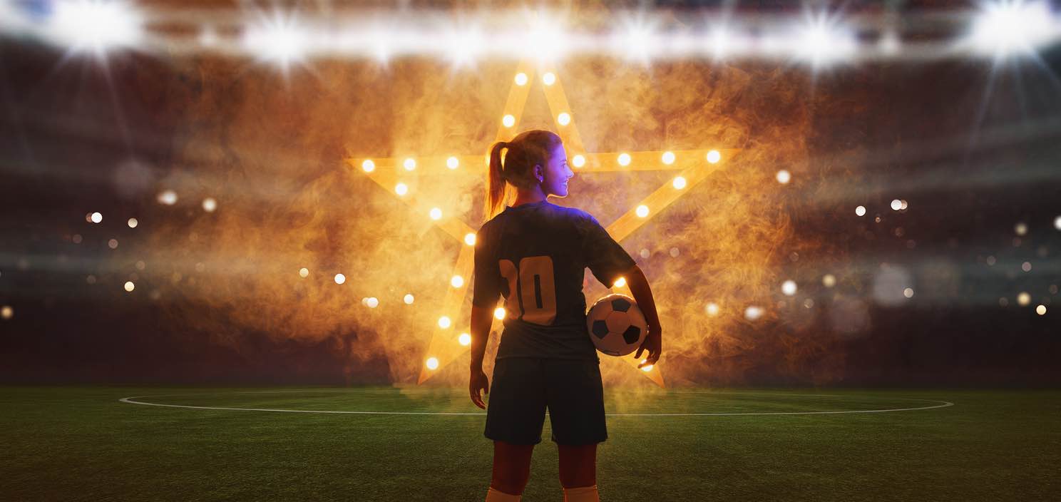 Female Footballer Standing infront of star