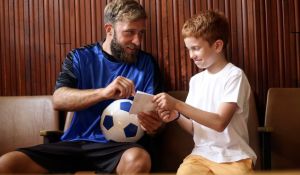 Athlete giving autograph to child